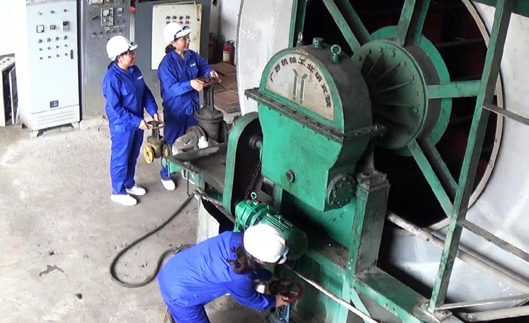 Nữ công nhân nhà máy vận hành hệ thống làm sạch nước mía (lọc bùn)